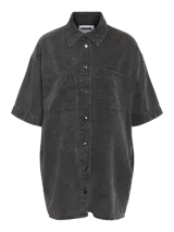 Vestido camisero de denim negro con lavado ácido, manga corta, cierre de botones, bolsillos frontales y corte holgado.