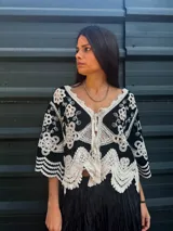 Camisa negra con detalles de crochet color crema, escote en V y mangas 3/4.