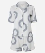 Conjunto de pijama corto blanco con estampado de soles azules. Incluye camisa de manga corta con cuello y short con cintura elástica.
