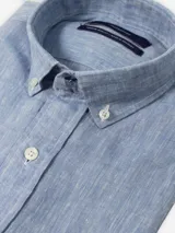 Camisa celeste de lino con cuello abotonado y corte clásico.