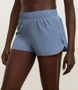 Short deportivo femenino color blanco, de poliéster, con cintura elástica, abertura lateral y bolsillo trasero.