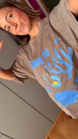 Remera marrón de corte holgado con estampado de motivos marinos en azul.