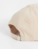 Gorra color beige con bordado frontal de la frase "Lucky Girl Club" y un trébol de cuatro hojas.