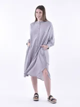 Vestido camisero midi a rayas verticales grises y blancas, con cuello mao y mangas largas abullonadas.