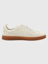 Zapatillas deportivas de cuero color blanco hueso con detalles en gamuza y suela de goma color caramelo.