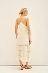 Vestido largo azul marino de breteles finos, línea "A" con volado en la parte inferior y detalles de puntillas alrededor de toda la prenda.