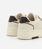 Championes urbanos de cuero sintético color crema con detalles en marrón.