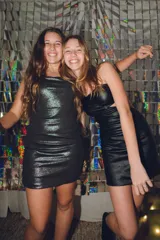 Minivestido negro de fiesta con un hombro descubierto y breteles finos que se cruzan en la espalda.