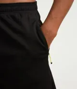 Bermuda deportiva masculina gris con cintura elástica, bolsillos laterales y cordón de ajuste.