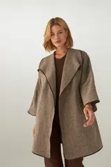 Tapado marrón de largo medio, abierto, con cuello y envivado. Hecho 100% en Uruguay con tela 100% lana fina sin teñir, diseñada exclusivamente por Don Baez.