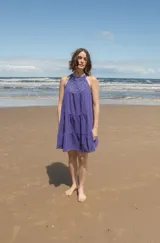 Vestido corto color naranja con escote halter de crochet tejido en hilo de algodón y falda escalonada.