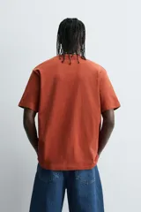 Remera color arena de corte recto, cuello redondo y mangas cortas.