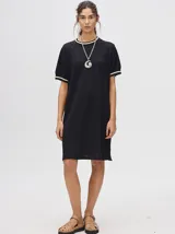 Vestido negro de corte recto y cuello redondo, con puños a rayas en color contrastante.