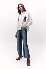 Camisa de calce holgado en algodón con bordados de flores multicolores en el frente.