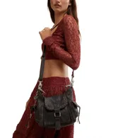 Bolso hobo pequeño de cuero color marrón oscuro con correa de hombro ajustable y removible, cierre magnético tipo solapa, bolsillos interiores con cremallera y compartimentos adicionales.