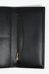 Billetera de estructura rígida color negro con logo metálico dorado de la marca Bimba y Lola en el frente. El interior cuenta con tarjetero y monedero con cierre de cremallera.