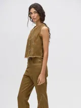 Pantalón de jean azul de tiro alto y corte oxford con apliques metálicos en bolsillos y laterales.