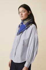 Pañuelo ligero con estampado a cuadros en tonos azules y detalles coloridos, ideal para aportar sofisticación.