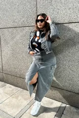 Falda larga gris de denim, con corte recto, abertura lateral y bolsillo cargo con solapa en la pierna.