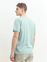 Remera manga corta con cuello redondo y tapeta con dos botones.