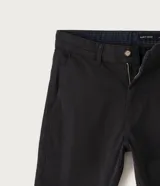 Pantalón masculino de sarga color beige, corte slim, con cierre de botón y cremallera, trabillas en la cintura y bolsillos delanteros y traseros.