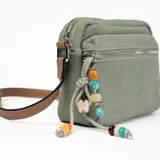 Bandolera verde de tela con correa marrón regulable y charms colgantes de cuentas de colores.