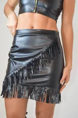 Pollera de cuero negro con flecos en el borde y diseño ajustado.