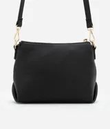 Bolso bandolera mediano de poliuretano negro con textura en relieve y logo triangular dorado. Tiene correa larga ajustable y desmontable, cierre de cremallera y bolsillo externo delantero.