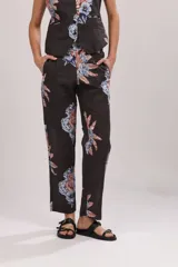 Pantalón de vestir gris con estampado de flores azules y naranjas. Corte recto, con bolsillos laterales y cintura elástica.
