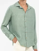 Camisa celeste de lino, de manga larga con botones de coco y parche de la marca.