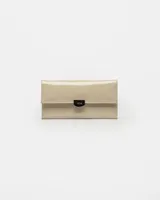 Billetera de cuero charol color beige con cierre frontal y diseño elegante.