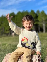 Sweater tejido de lana merino color crema con diseño de gallo bordado en la parte inferior izquierda.