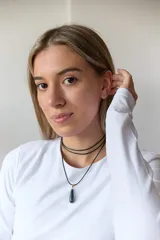 Gargantilla doble con choker de cuero negro y collar con dije de piedra natural marrón en forma de gota con engarce de acero quirúrgico hipoalergénico y tiento negro.