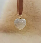 Gargantilla con cinta de terciopelo color beige y dije de nácar con forma de corazón.