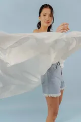 Top blanco con breteles finos, escote en V y volados en el frente.
