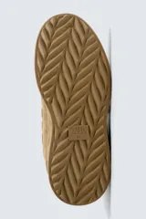 Zapatilla estilo skate de diseño robusto, confeccionada en una combinación de piezas de gamuza y material textil acolchado. Presenta un sistema de cierre con cordones gruesos y una tira de velcro en el empeine, junto con una suela de plataforma con relieve irregular.