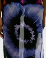 Vestido midi de tul transparente con estampado floral en tonos violeta, negro y rosa. Diseño sin mangas, corte ajustado y cuello choker.