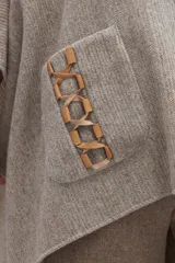 Poncho de lana color marrón con cuello alto, mangas 3/4 y bolsillo lateral con detalle de botones de cuero.