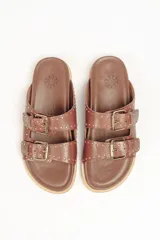Sandalias marrones de cuero vacuno con doble tira y hebillas metálicas ajustables.