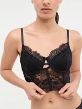 Bustier de encaje negro con copas con aro y breteles finos regulables.