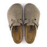 Zueco de ante color taupe con hebilla decorativa y suela de goma antideslizante.