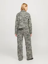 Pantalón de pierna ancha con estampado de cebra, tiro alto, cierre con cremallera y múltiples bolsillos.