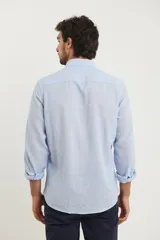 Camisa azul marino de lino y algodón, con cuello abotonado, manga larga con puños enrollados, bolsillo de parche en el pecho y cierre frontal con botones.