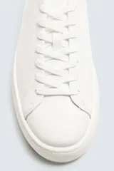 Zapatillas urbanas de cuero color blanco, con cordones y suela de goma con plataforma.
