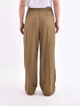 Pantalón de vestir color oliva, de corte amplio y tiro alto, con pinzas en la cintura y textura arrugada.