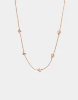 Collar corto dorado oro rosa con cadena fina y dijes de corazones pequeños distribuidos a lo largo de la cadena.