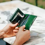 Billetera compacta de cuero genuino color verde con sistema de caja de aluminio para tarjetas con mecanismo de deslizamiento. Incluye clip para billetes y espacio adicional para documentos. Posee protección RFID.