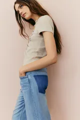 Remera de algodón color beige con cuello redondo y estampado de un auto Camaro con texto en tonos marrones y naranjas.