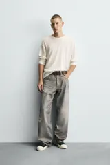 Pantalón de jean gris con corte holgado y efecto lavado en toda la prenda.