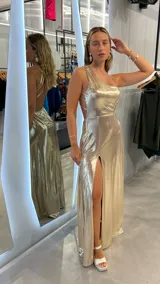Vestido largo dorado de fiesta, con un solo hombro y abertura en la pierna.